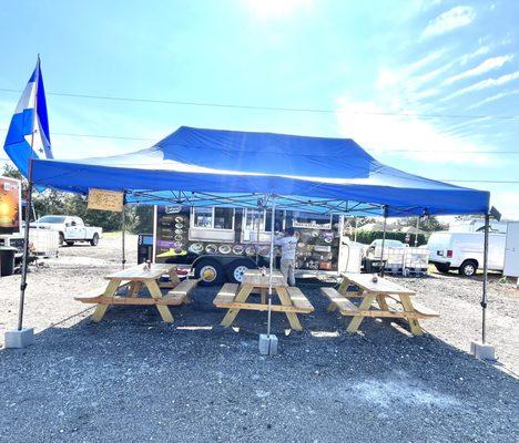 The food truck with tent and tables to eat