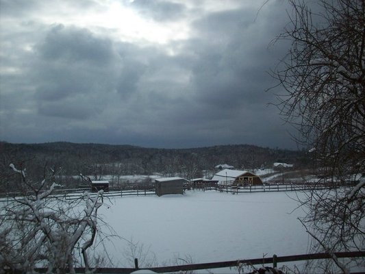 a view of the lower part of the property from the top portion by the arena showing the open land covered with a thin layer of Santa's snow