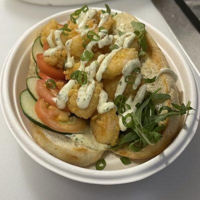 Crispy Shrimp Po' Boy, with jalapeño Remolaude sauce, tomatoes, and arugula on a toasted hoagie.