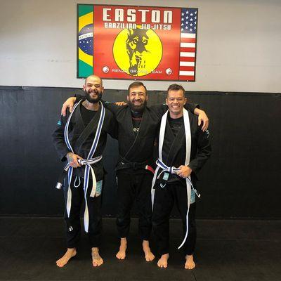 Professor Peter with students who've just earned new stripes on their white belts