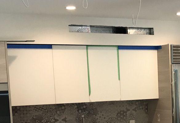 Glass cabinet (green tape) smashed, cabinets installed at an angle (large gap on left)