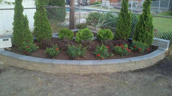 Retaining wall with shrub installation.  Happy customer job was done on time within budget!!