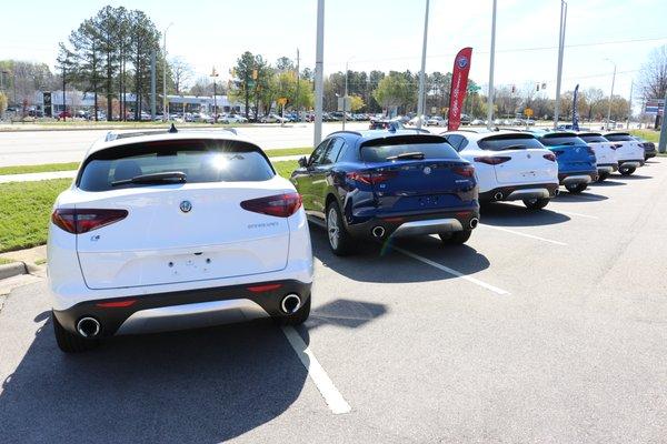 A line of 2018 Alfa Romeo Stelvio SUVs facing Capital Blvd. at Leith Alfa Romeo of Raleigh.