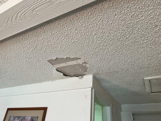 Popcorn ceiling texture needing to be repaired due to water damage from a leaky roof