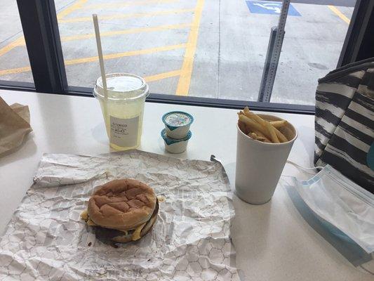 A bacon cheeseburger with French fries, ranch, and a drink.