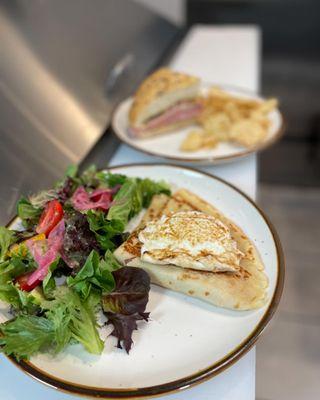 Ham & Cheese Crepe in front.  Muffuletta sandwich in background.