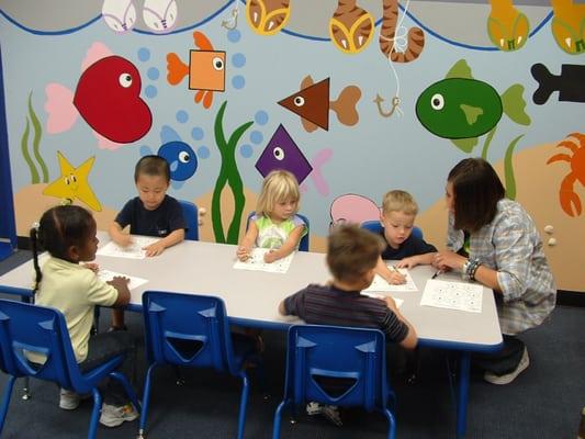 One on one teacher interaction with children while teaching a lesson.