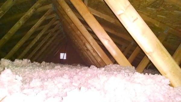 Attic prior to Mooney & Moses install. Note height of insulation and pink color.