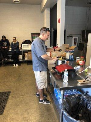 Cal High Coach Brian Bordier stirring the secret nacho cheese sauce while "The Famous Elsy" supervises.