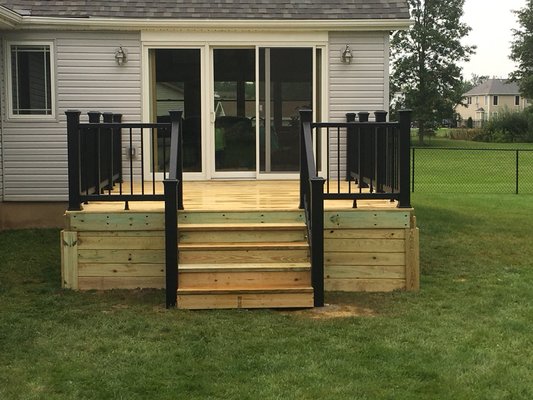 Pressure treated deck with trex black railings designed by the owner of Jameson Remodeling