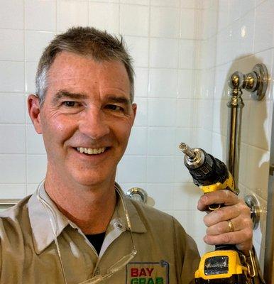 Helping prevent falls by installing Moen Grab grab bars in a tiled shower surround  using a diamond core bit and a water jet.