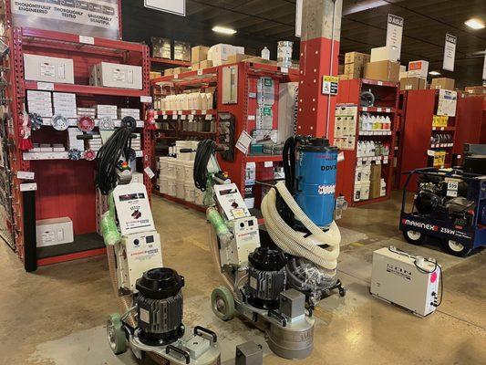 Concrete grinders and dust collection equipment in front of rows of products inside Jon-Don Denver