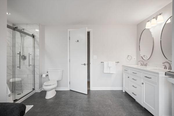 Minimalist elegance: A sleek bathroom design featuring a contrasting dark floor and white cabinetry.