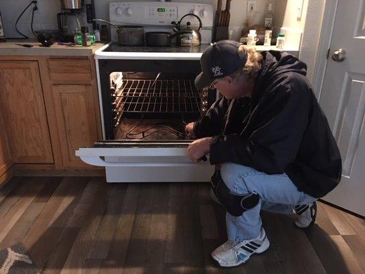 Western Appliance Repair Tech Fixing Oven Door