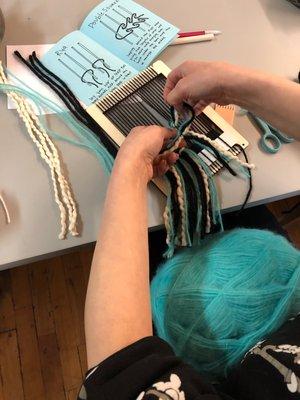 Workshop attendees working on woven tapestry wall hangings