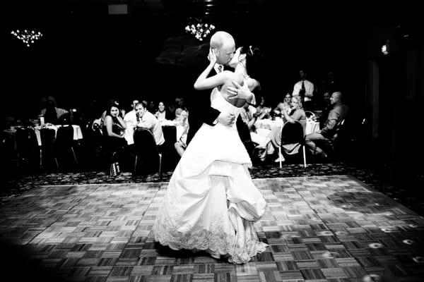 first dance of newly weds in black and white kissing