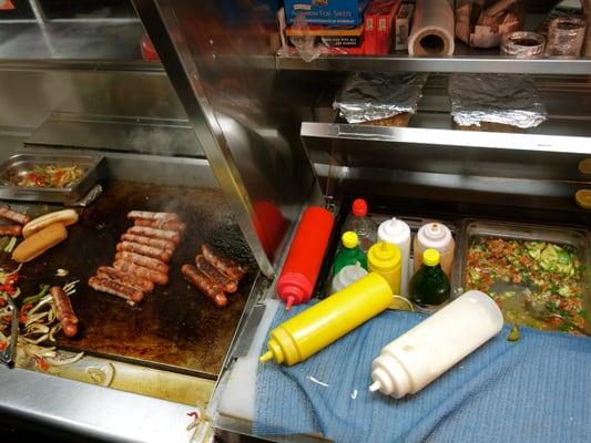 Bacon Wrapped Hot Dogs with Onions, Peppers, Avocado, Pico de Gallo and Grilled Jalapeno.