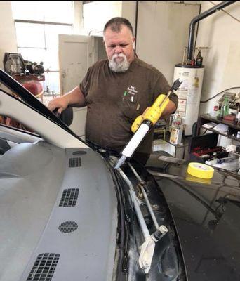 Applying adhesive before installing a new windshield