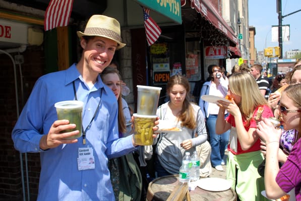 Jonah proffering Pickle Guys pickles to hungry clients, on our Ethnic Eats tour of the Lower East Side.