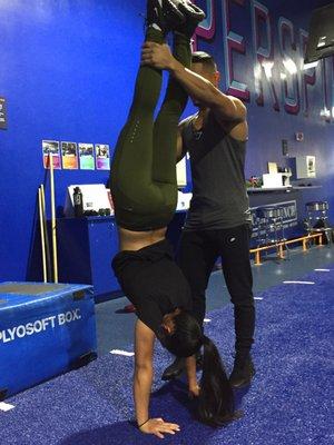 Personal Trainer Alex S. guiding with the proper handstand hold technique