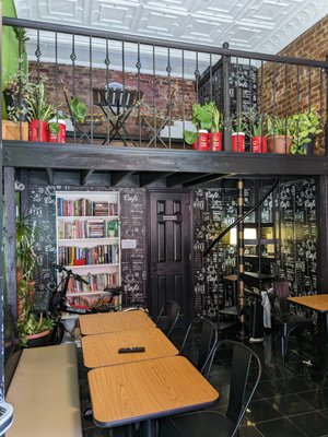 A truly fascinating eating room with a spiral staircase and interesting books.