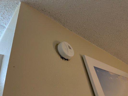 Holes in wall below smoke detector