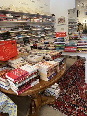 Books on tables, shelves, and under tables