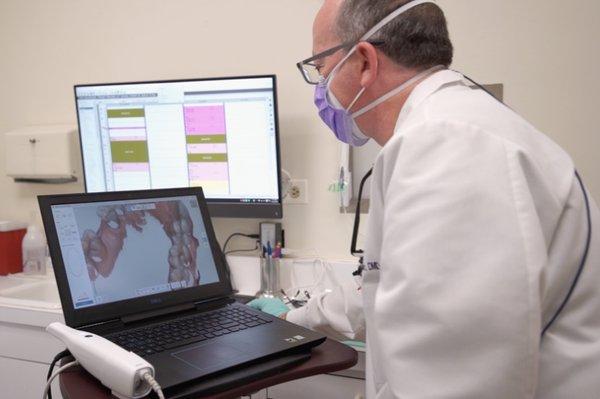 Dr. Mitchell Rubinstein reviewing a patient's plan of care with the latest dental technology