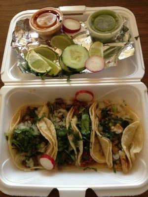 Delicious tacos!   2 asada (beef), 1 chorizo, and 1 pollo!  With cilantro, onions, lime, radish, cucumbers, and sauces!