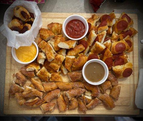 Charcuterie board with mini pretzel dogs, pepperoni pretzel, cheese pretzel, & cinnamon sugar pretzel