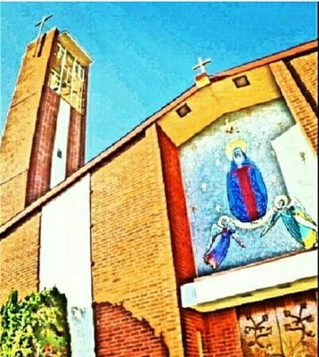 art above the front door with the bell tower in the background