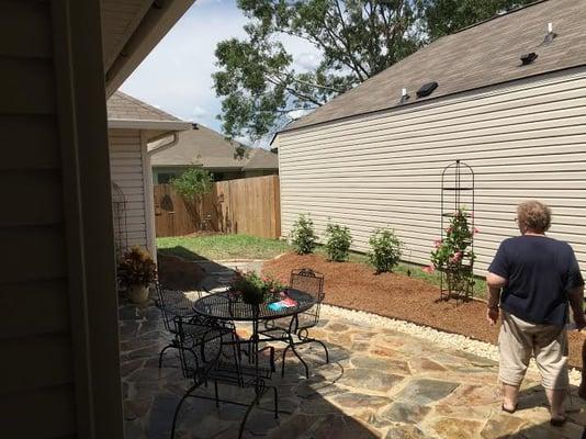 beds extended and rock drainage added ,also pathway added around patio