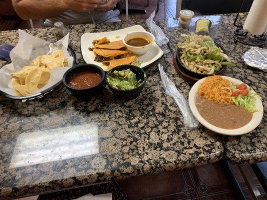 Fresh chips, salsa, & guacamole with chicken fajitas and birria tacos.