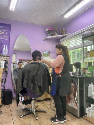 Carolina cutting my son's hair. See the saints in the corner. We are blessed.