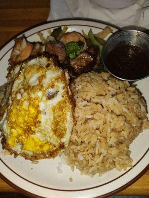 Steak and shrimp with a fried egg on top for egg fried rice