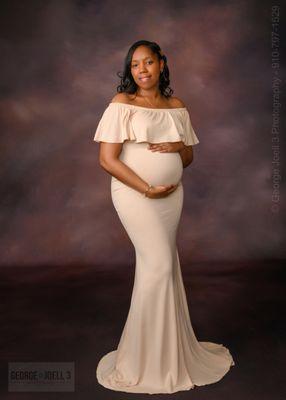 Mother-to-be in studio with a tan maternity dress.