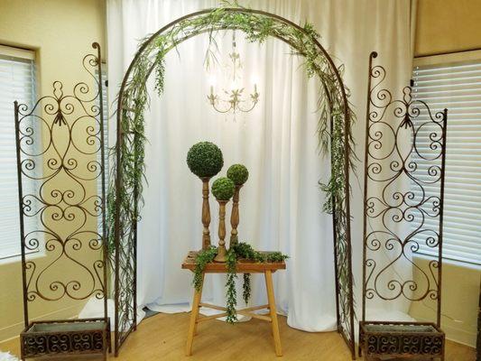 Simple Metal Arch, White Backdrop, Vintage Scrollwork Screen, Sliced Wood Table, Small Chandelier, Wood Candlesticks with Moss Balls