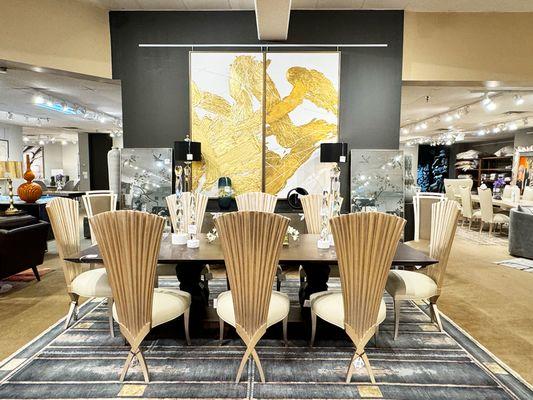 Sophistication and art converge in Noel Furniture's dining collection, featuring statement-making chairs and an enchanting gold mural & rug.