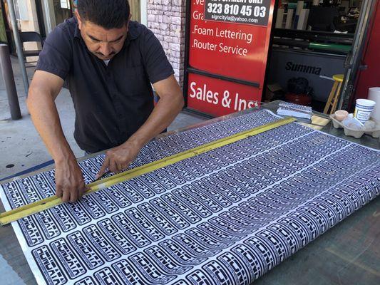 My man working and cutting for thousands of stickers