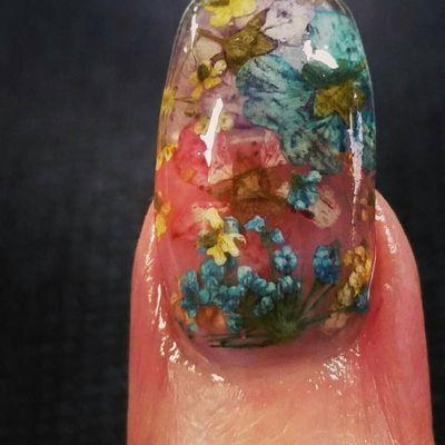 Dried flowers inlayed in an acrylic nail. Beautiful!