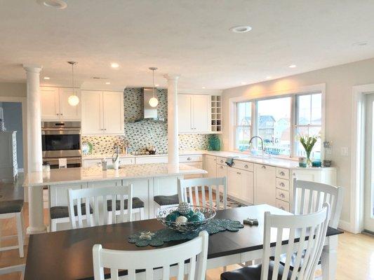 This beach house kitchen is full of natural light which highlights the "Park Place" cabinetry by Medallion.