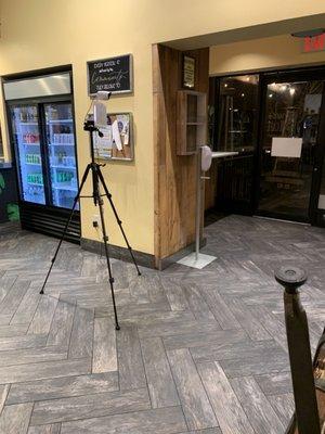 Temperature scanners and hand sanitizer next to entrance