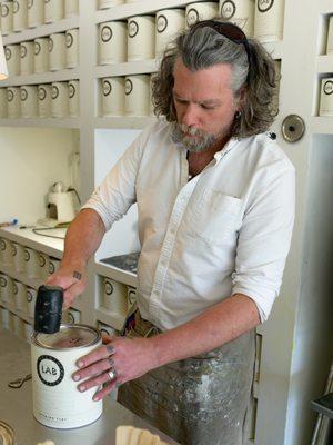 A Colorist seals a gallon of paint