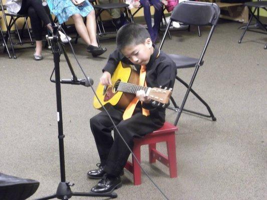 Young student playing classical guitar