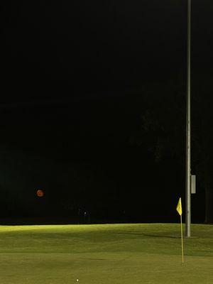 Night golfing on the Par 3 course with blood moon out