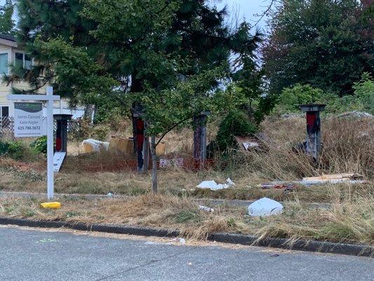 Abandoned and trashed lot with needles and homeless encampment owned by Thomas James Homes