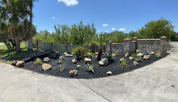 Installation of rock bed, large rocks and variety of cacti plants.