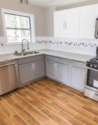 Beautiful marble counter tops with freshly painted cabinets.