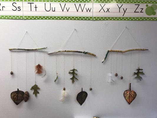 Autumn mobiles with leaf rubbings and seasonal artifacts.