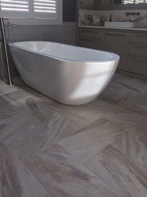 Master bath porcelain tile floor with free standing tub